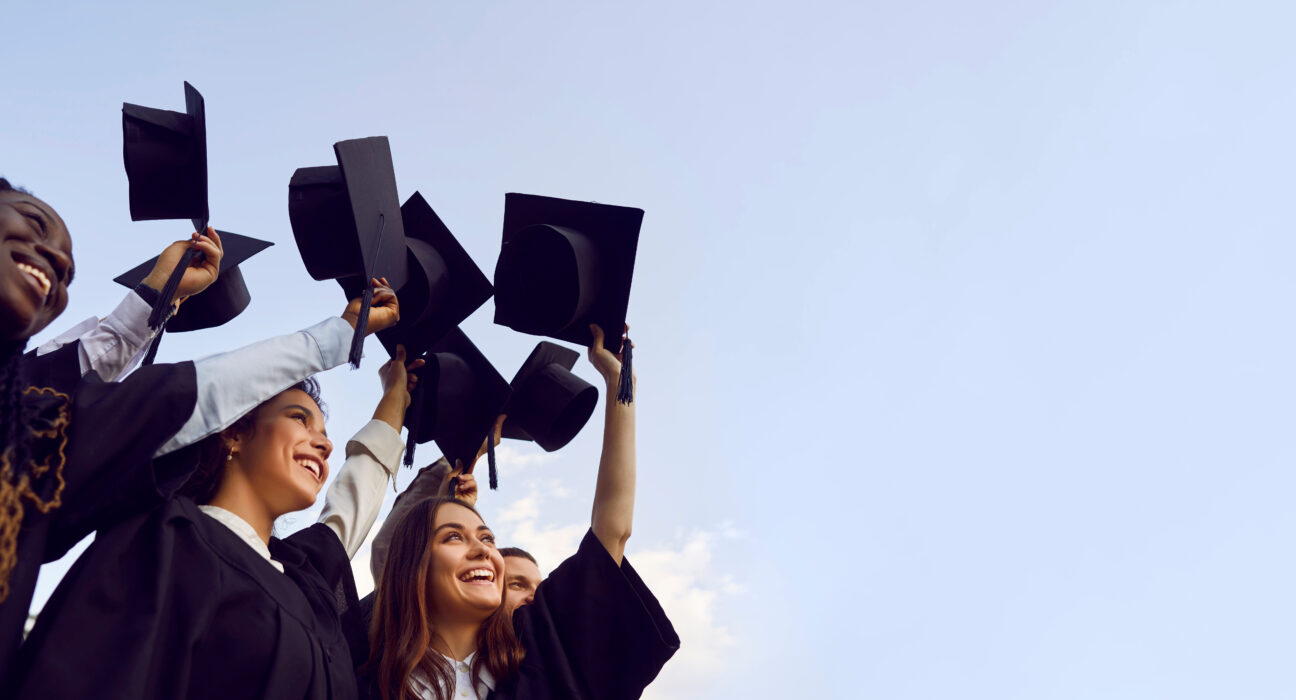 Group of graduates raising their caps into the sky during a celebration